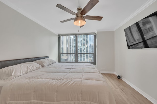 bedroom featuring light hardwood / wood-style flooring, ornamental molding, and ceiling fan