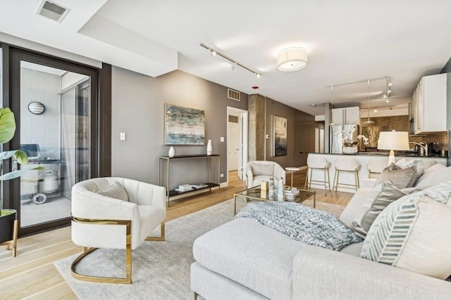 living room featuring track lighting and light hardwood / wood-style floors