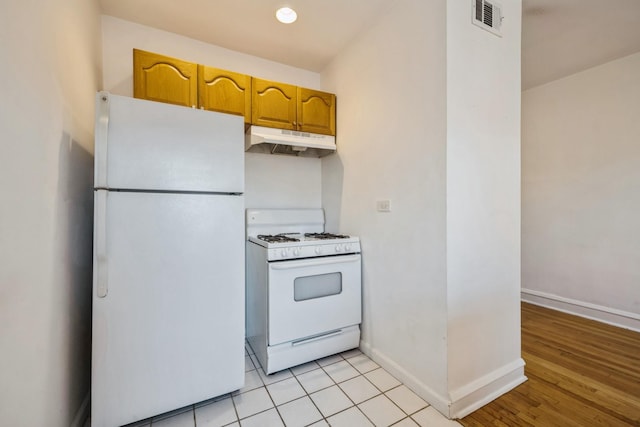 kitchen featuring light tile patterned floors and white appliances