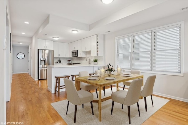 dining space featuring sink and light hardwood / wood-style flooring