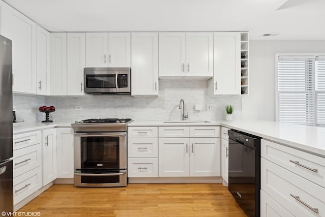 kitchen featuring stainless steel appliances, white cabinetry, and sink