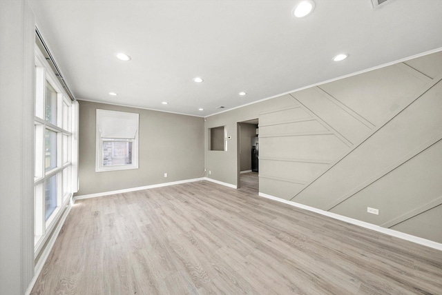 unfurnished room with crown molding and light wood-type flooring