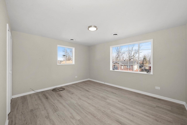 spare room with light hardwood / wood-style flooring and a wealth of natural light