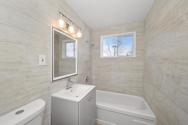 full bathroom featuring tiled shower / bath combo, vanity, tile walls, and toilet