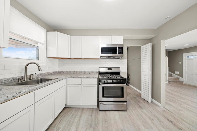 kitchen featuring appliances with stainless steel finishes, sink, and white cabinets