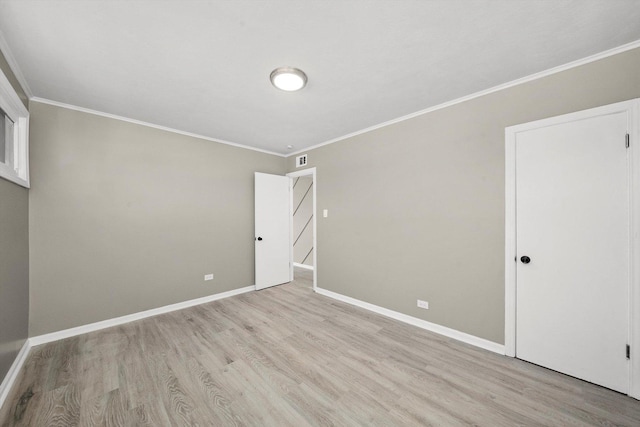 empty room featuring ornamental molding and light hardwood / wood-style floors