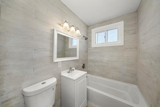 bathroom featuring vanity, tile walls, and toilet