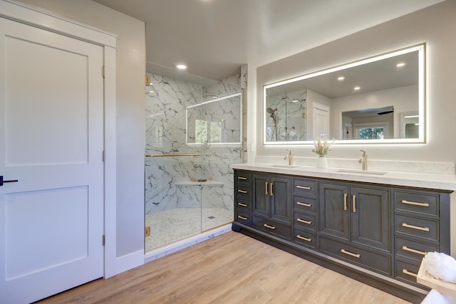 bathroom with vanity, hardwood / wood-style floors, and a shower with door