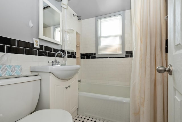 full bathroom with shower / bath combination with curtain, vanity, toilet, and tile walls