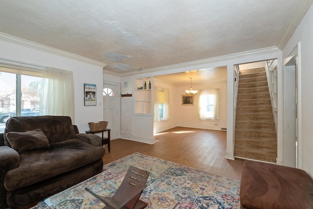 living room featuring an inviting chandelier, hardwood / wood-style flooring, crown molding, and a textured ceiling