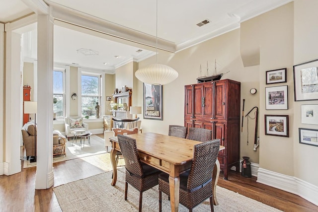 dining room featuring wood-type flooring and ornamental molding