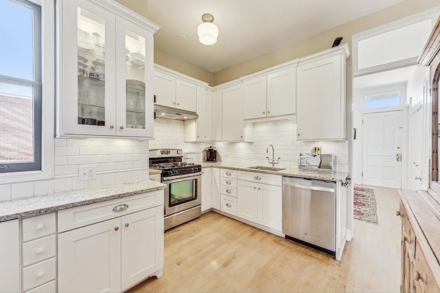 kitchen with white cabinetry, stainless steel appliances, light hardwood / wood-style floors, and sink