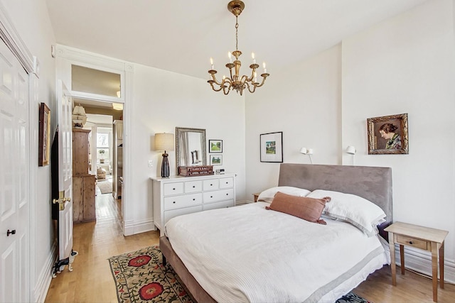 bedroom featuring a notable chandelier and light wood-type flooring