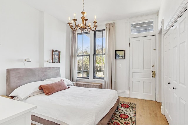 bedroom with an inviting chandelier and light wood-type flooring