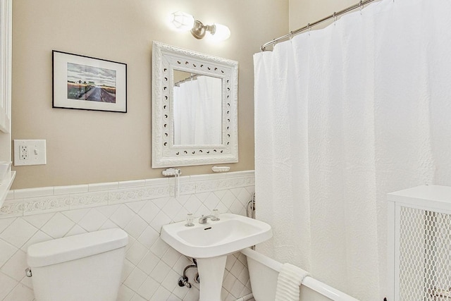 bathroom with tile walls and toilet