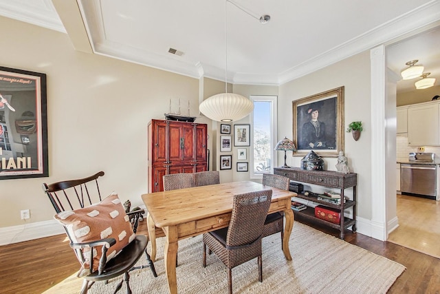 dining room featuring hardwood / wood-style floors and crown molding