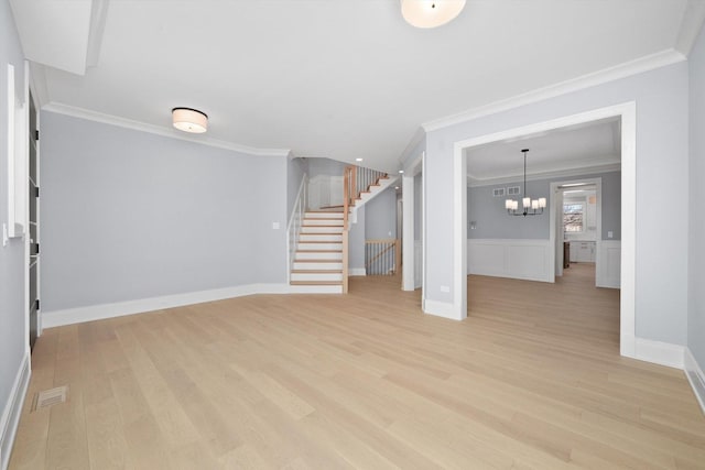 unfurnished living room with an inviting chandelier, crown molding, and light wood-type flooring