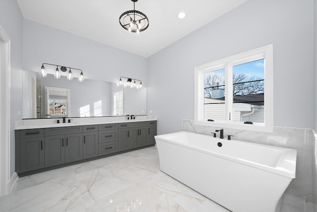 bathroom with vanity, a tub, a healthy amount of sunlight, and an inviting chandelier