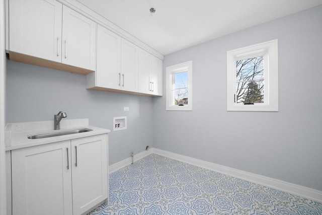 clothes washing area featuring cabinets, sink, and washer hookup