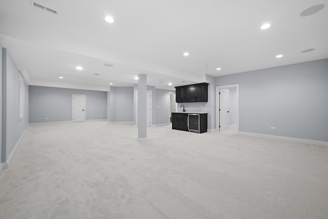 basement featuring light colored carpet and indoor wet bar