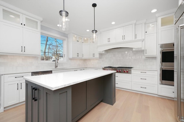 kitchen with sink, white cabinetry, decorative light fixtures, a center island, and stainless steel appliances