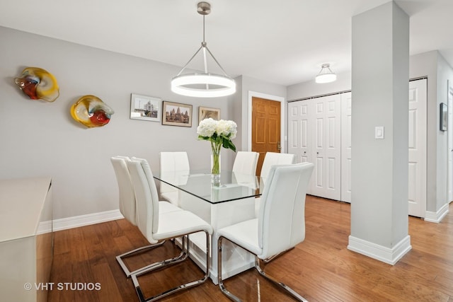 dining space featuring wood finished floors and baseboards