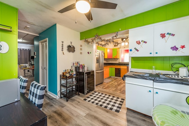 kitchen featuring tasteful backsplash, ceiling fan, light hardwood / wood-style floors, and stainless steel fridge with ice dispenser