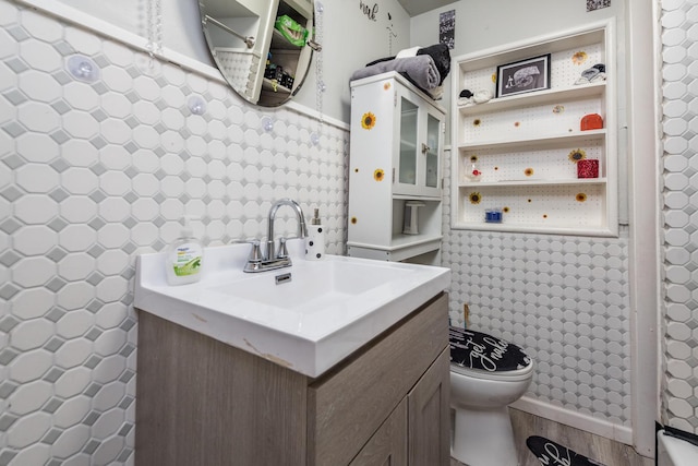 bathroom featuring vanity, tile walls, and toilet