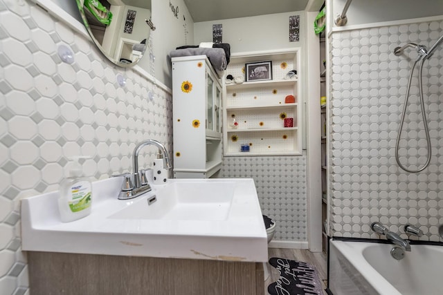 bathroom with sink, hardwood / wood-style flooring, and shower / washtub combination