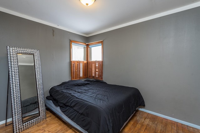 bedroom with wood-type flooring and ornamental molding