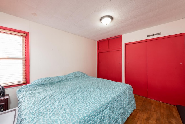 bedroom with dark hardwood / wood-style flooring and a textured ceiling