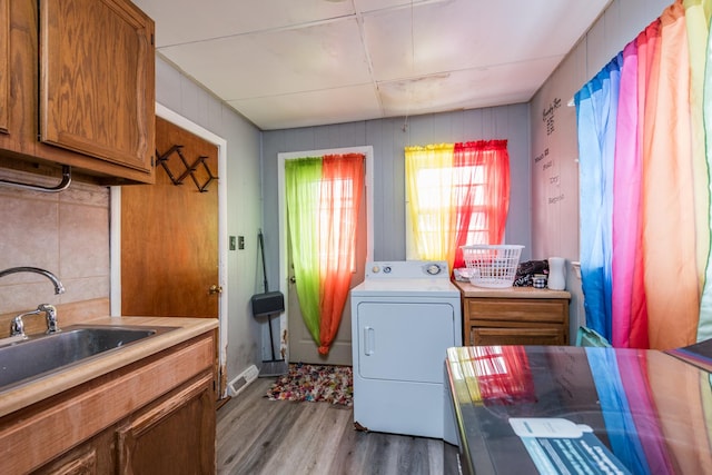 laundry room featuring hardwood / wood-style flooring, washer / dryer, sink, and cabinets