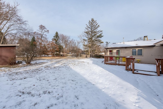 snowy yard with a wooden deck