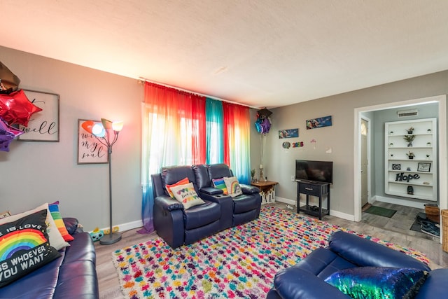 living room with a textured ceiling and light wood-type flooring