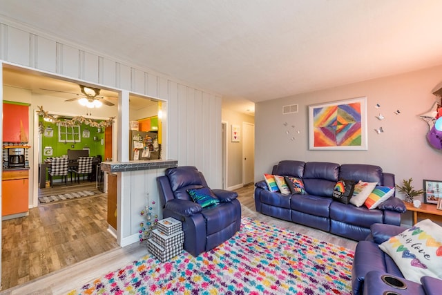 living room with light hardwood / wood-style flooring and ceiling fan