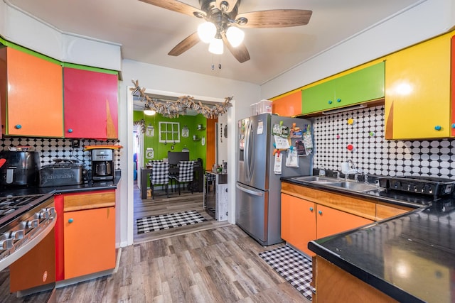 kitchen with sink, light hardwood / wood-style flooring, ceiling fan, and appliances with stainless steel finishes