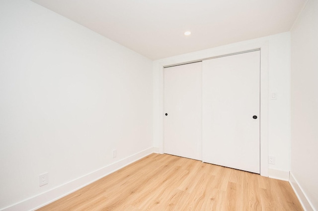 unfurnished bedroom with light hardwood / wood-style flooring and a closet