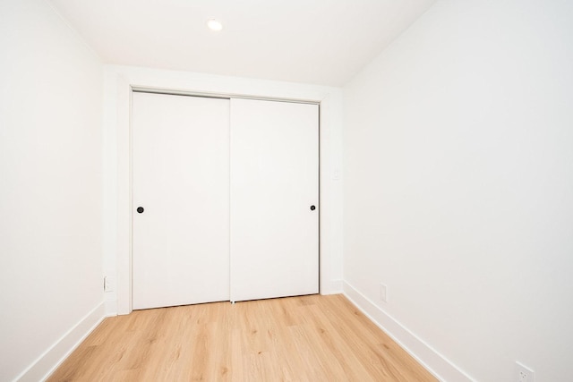 unfurnished bedroom with a closet and light hardwood / wood-style flooring