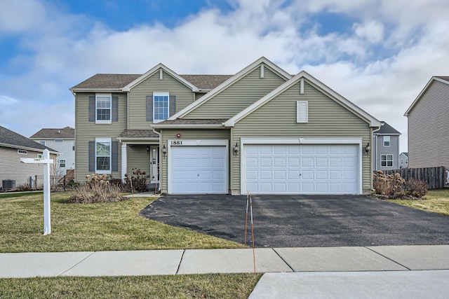 view of front of property featuring central AC, a garage, and a front lawn