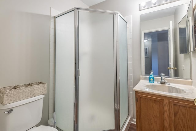 bathroom featuring vanity, toilet, and walk in shower