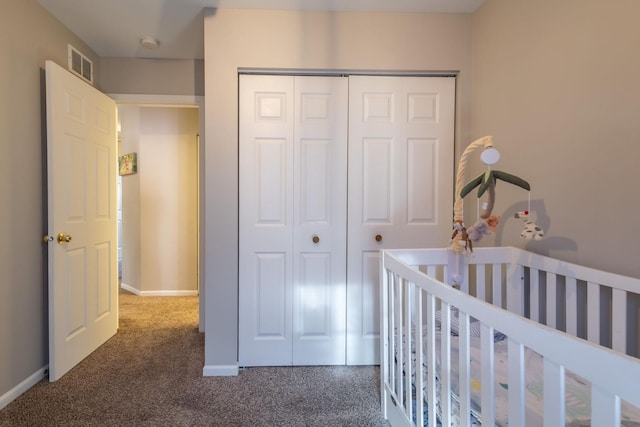 unfurnished bedroom featuring a crib, a closet, and dark colored carpet