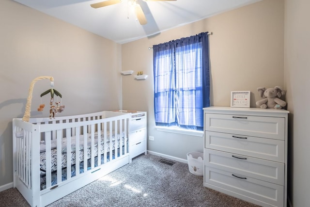 bedroom featuring a nursery area, multiple windows, and dark colored carpet