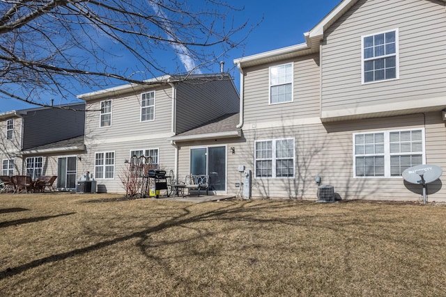 rear view of property featuring a yard and central air condition unit