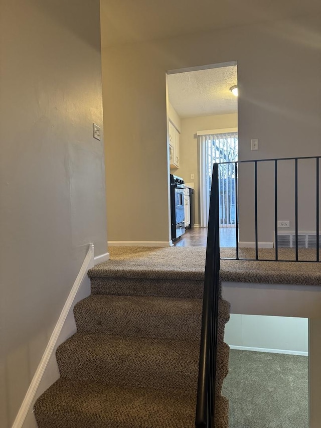 staircase featuring a textured ceiling