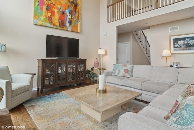 living room with hardwood / wood-style floors and a high ceiling