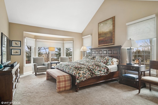 carpeted bedroom featuring high vaulted ceiling and multiple windows