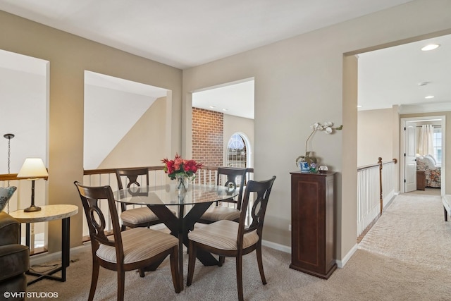 dining room featuring a healthy amount of sunlight and light colored carpet