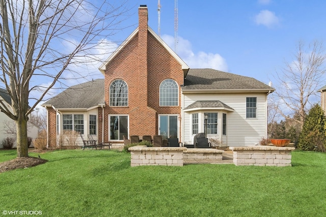 rear view of house with a lawn and a patio area