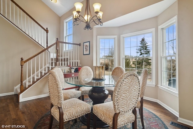 dining space featuring dark hardwood / wood-style flooring, a wealth of natural light, and a chandelier