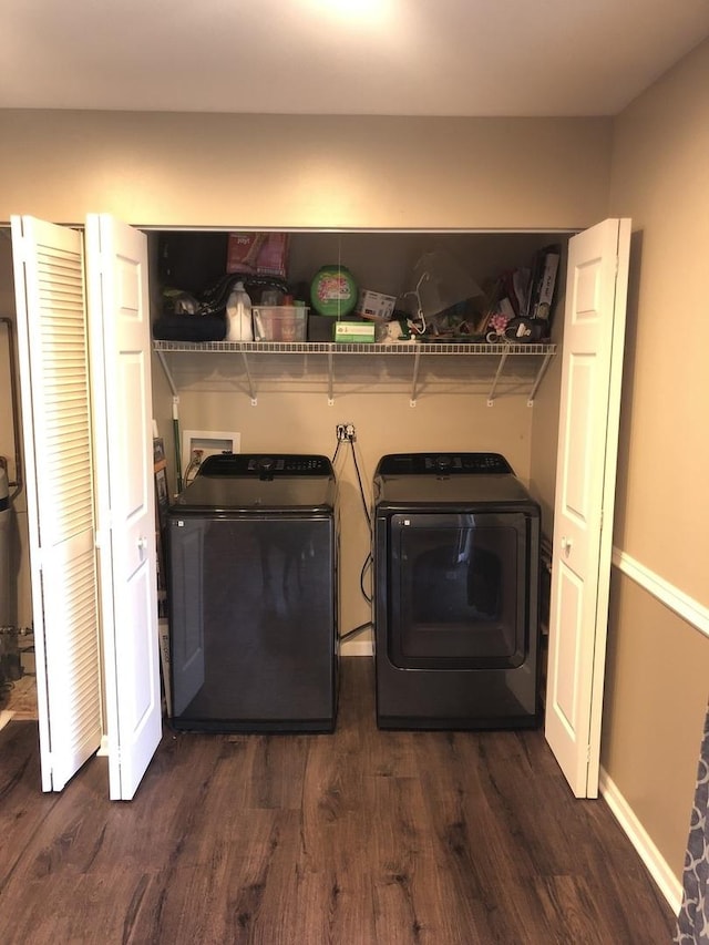 washroom with dark wood-type flooring and washing machine and dryer